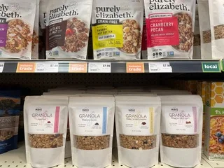 Mary's All Natural granola pouches stocked on a grocery shelf with a local shelf tag.