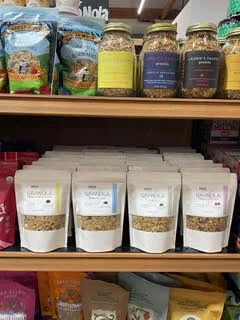 Mary's All Natural granola pouches stocked beneath other pantry items on a store shelf.